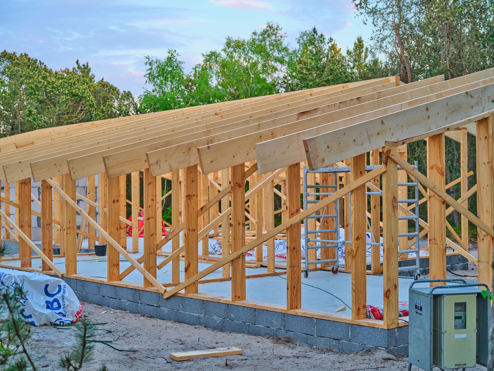 Wooden structure under construction in Denmark surrounded by greenery